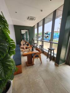 a restaurant with wooden tables and chairs and windows at Lennox Z in Accra