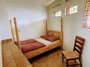 1 dormitorio con cama de madera y silla en Banda Lodge en Masaka