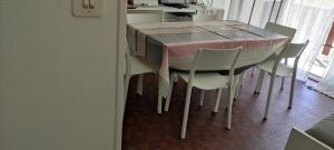 a dining room table with white chairs and a pink table cloth at appartement T1bis St Lary soulan village in Saint-Lary-Soulan +10 photos