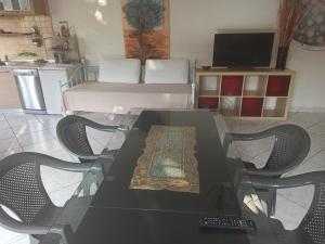 een glazen tafel en stoelen in de woonkamer bij Διαμέρισμα 110 Μ στον Λαγκαδά in Lagadas