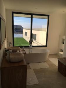 a bathroom with a tub and a large window at Villa de prestige in Saint-Paul