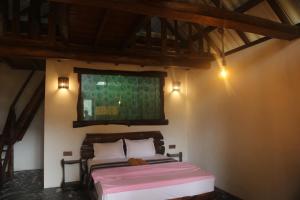 a bedroom with a bed and a painting on the wall at Green Cloud Villa in Ella