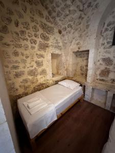 a bedroom with a bed in a stone wall at Petra Hotel & Coffee House in Urfa