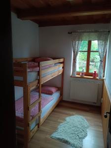 a bedroom with two bunk beds and a rug at Chalupa U kapličky 