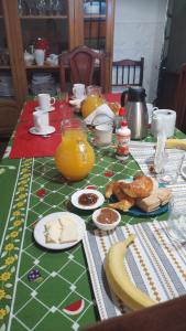 a table with breakfast foods and a banana and orange juice at Residencia La Isabel in San Luis