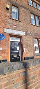 a brick building with a black door with a sign on it at Entire Flat with Three Bedrooms N 2 in Great Yarmouth +3 photos
