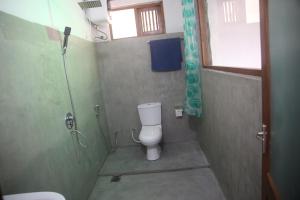 a small bathroom with a toilet and a shower at Green Cloud Villa in Ella