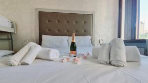 a white bed with a bottle of champagne and towels at Romerooms Condotti in Rome