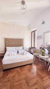 um quarto com uma grande cama branca e pisos em madeira em Romerooms Condotti em Roma