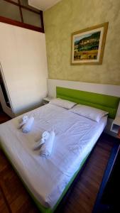 uma grande cama branca com duas toalhas em Romerooms Condotti em Roma
