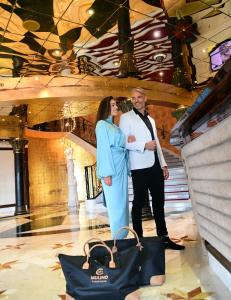 Ein Mann und eine Frau stehen in einer Lobby mit Taschen in der Unterkunft Mulino Luxury Boutique Hotel in Buje
