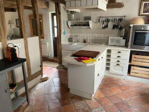 a kitchen with white counters and a white refrigerator at LE CLOS DU BENESTAR in Mauvezin-dʼArmagnac