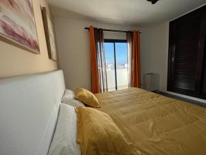een slaapkamer met een groot bed en een raam bij HOUSE WHITE BEACH in Playa Blanca