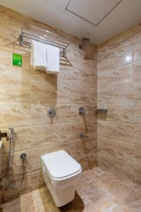 a bathroom with a toilet and a shower at Lotus Grand Mumbai Near International Airport in Mumbai
