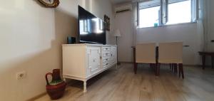 a living room with a television on a dresser with two chairs at Apartment Factory in Dubrovnik