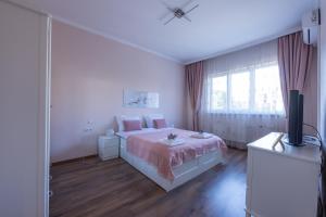 - une chambre blanche avec un lit et une télévision dans l'établissement Julie Suite Top Center, à Sofia