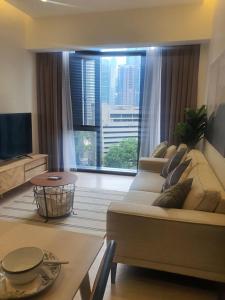 a living room with a couch and a large window at KLCC Ritz Residence STAR in Kuala Lumpur