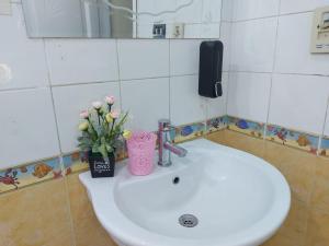 um lavatório de casa de banho com um telefone e flores nele em Malak Guest House no Cairo
