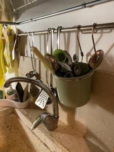 a bucket of kitchen utensils sitting on a sink at TumHouse (la capanna di zio Tom) in Ceglie Messapica