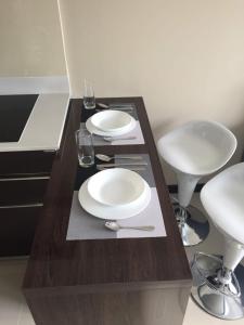 a table with two white plates and glasses on it at Mai Khao Beach Apartments in Mai Khao Beach +7 photos