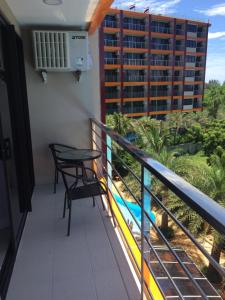 balkon ze stołem i krzesłami oraz widokiem na budynek w obiekcie Mai Khao Beach Apartments w mieście Ban Bo Sai Klang