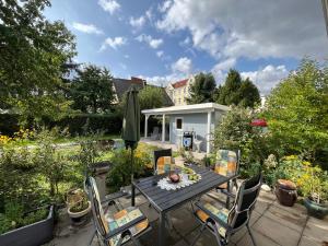 een patio met een tafel en stoelen in een tuin bij Elbidyll in Maagdenburg