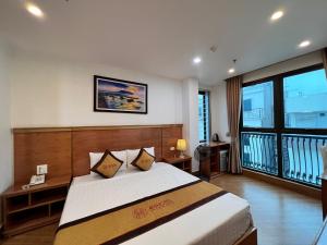 ein Schlafzimmer mit einem großen Bett und einem Balkon in der Unterkunft 4M2 Hotel in Hòa Ðình
