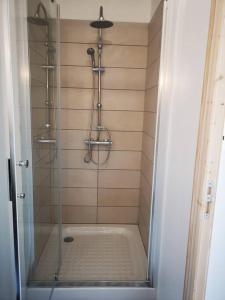 La salle de bains est pourvue d'une douche avec une porte en verre. dans l'établissement T2 - Appartement 1 chbre Wissant, à Wissant