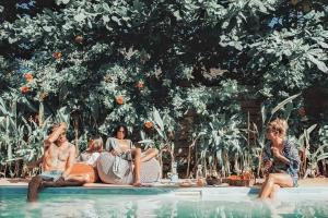un gruppo di persone sedute in una piscina di Sleepy Gypsea Villa Siargao - Private Room - Daydream a Catagnan
