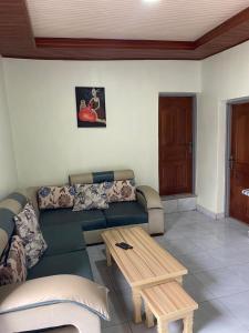a living room with a couch and a coffee table at KANOMBE AIRPORT BED& BREAKFAST in Kigali