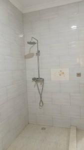 a white shower with a shower head in a bathroom at KANOMBE AIRPORT BED& BREAKFAST in Kigali