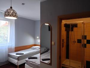 łazienka z lustrem, łóżkiem i prysznicem w obiekcie ZAJAZD Wałbrzych w Wałbrzychu