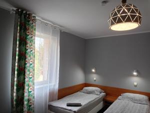 een slaapkamer met 2 aparte bedden en een raam bij ZAJAZD Wałbrzych in Wałbrzych