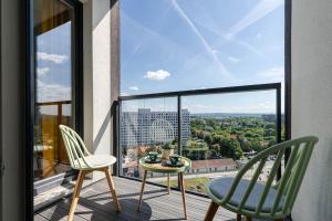 a balcony with two chairs and a table and a view at BlueApart Mogilska in Kraków