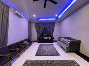 - un salon avec un canapé et des lumières bleues dans l'établissement homestay kuala kedah, à Kuala Kedah