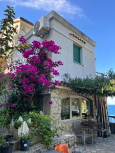 ein Haus mit lila Blumen auf der Seite in der Unterkunft Apartment Ilario in Cres