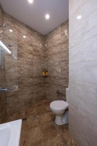 La salle de bains est pourvue de toilettes, d'une douche et d'un lavabo. dans l'établissement Julie Suite Top Center, à Sofia