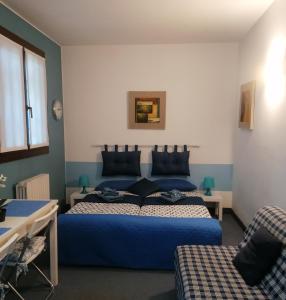 1 dormitorio con 2 camas azules y sofá en B&B- La Casa Blu- Forum di Assago, Humanitas, Milanofiori, IEO, en Rozzano