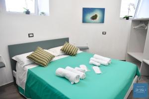 ein Schlafzimmer mit einem blauen Bett und Handtüchern darauf in der Unterkunft Di Vaio’s Apartments in Neapel