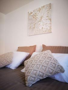 1 cama con almohadas y una foto en la pared en T3 - Appartement jardin Wissant 6 personnes, en Wissant