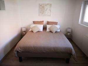 una camera da letto con un grande letto con cuscini di T3 - Appartement jardin Wissant 6 personnes a Wissant