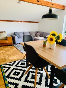 a living room with a wooden table and a couch at Schöne, große Ferienwohnung direkt am Donauradweg & Keltenstadt Heuneburg in Herbertingen