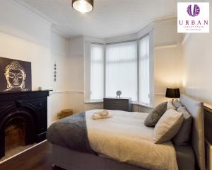 a bedroom with a large bed and a window at 4 Bedroom House, Perfect For Business , Relocation, Contractors, Families By Urban Luxury Stays Short Lets & Serviced Accommodation Liverpool & Free Parking in Liverpool