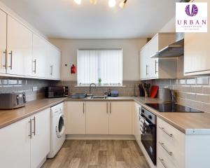 a kitchen with white cabinets and a sink at 4 Bedroom House, Perfect For Business , Relocation, Contractors, Families By Urban Luxury Stays Short Lets & Serviced Accommodation Liverpool & Free Parking in Liverpool