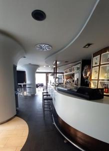 a restaurant with a bar with chairs and tables at Albergue cafetería Río Sar in Padrón