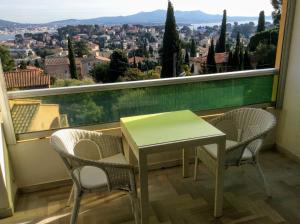 d'une table et de chaises sur un balcon avec vue. dans l'établissement Hauts de Portissol 50 m2 terrasse 12 m2 Vue mer, à Sanary-sur-Mer