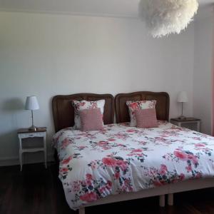 1 Schlafzimmer mit einem Bett mit Blumenbettdecke in der Unterkunft Gîte breton au bord du GR34 in Landunvez