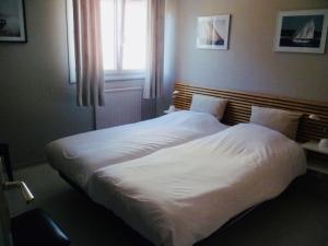 two beds in a bedroom with a window at Hauts de Portissol 50 m2 terrasse 12 m2 Vue mer in Sanary-sur-Mer