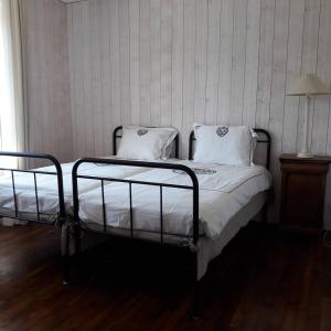 1 Schlafzimmer mit 2 Betten mit weißer Bettwäsche und einer Lampe in der Unterkunft Gîte breton au bord du GR34 in Landunvez