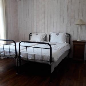 a bedroom with two beds with white sheets and a lamp at Gîte breton au bord du GR34 in Landunvez